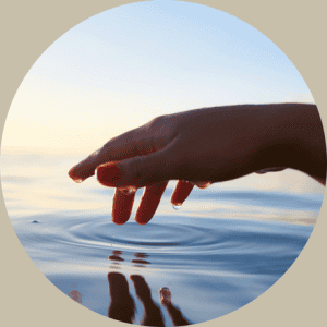 Hand im Sonnenuntergang auf Wasseroberfläche