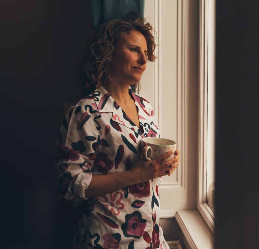 Müde Frau schaut aus dem Fenster